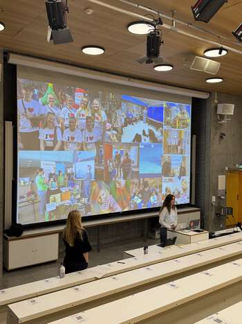To kvinner står foran i et auditorium og snakker til publikum