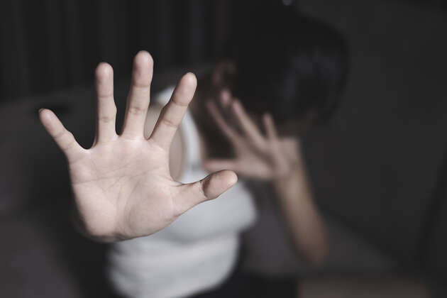 Bildet viser en ung person som holder opp en hånd foran kamera, ansiktet er skjult. 