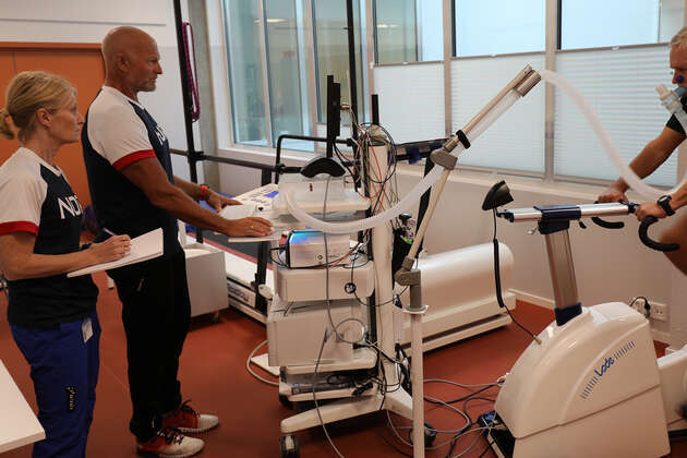 Bildet viser to personer som følger målinger på skjerm mens en tredje person sykler på testlab. 