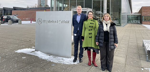 en mann og to damer ved siden av et skilt med teksten: Høgskolen i Østfold