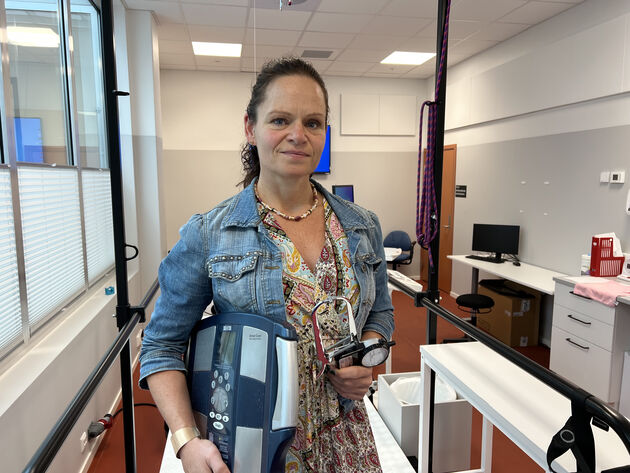 Forsker fotografert på høgskolens treningslab med en vekt under armen. 