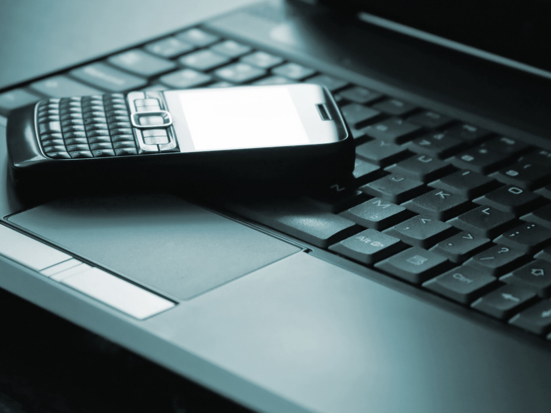 Bildet viser en mobiltelefon plassert på et pc-tastatur. 