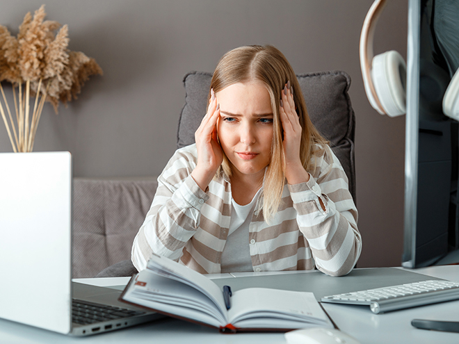 Bildet av en kvinne foran pc-skjermen som åpenbart er frustrert og sliten. 