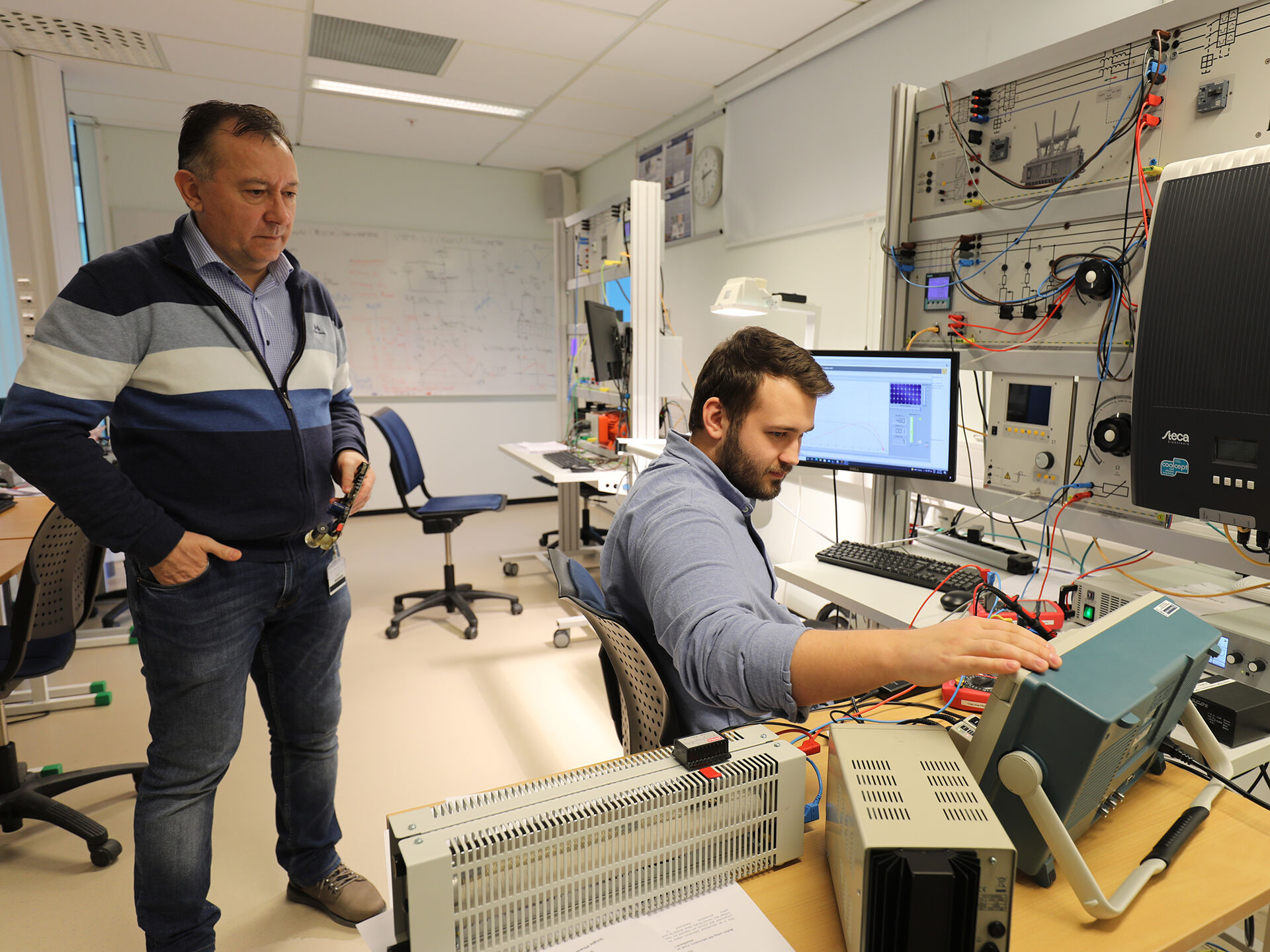 Bildet viser student og foreleser i arbeid på høgskolens elektrolab. 