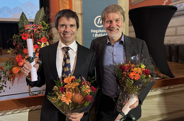 Bildet viser de to prisvinnerne side om side med hver sin blomst og diplom. 