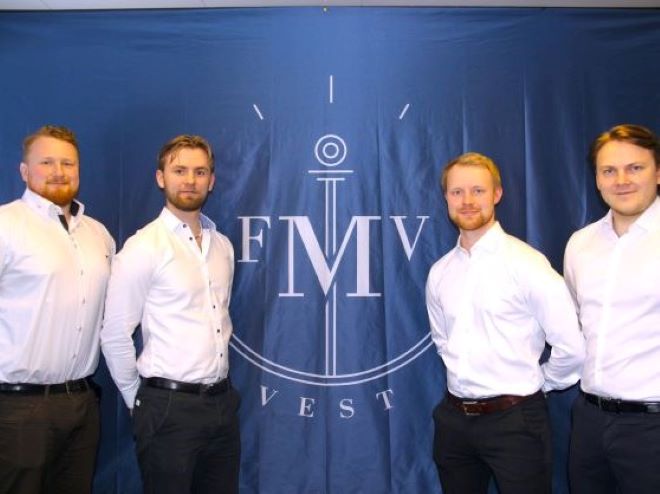 The four project members stand on a row in front of a blue background with text FMV. 