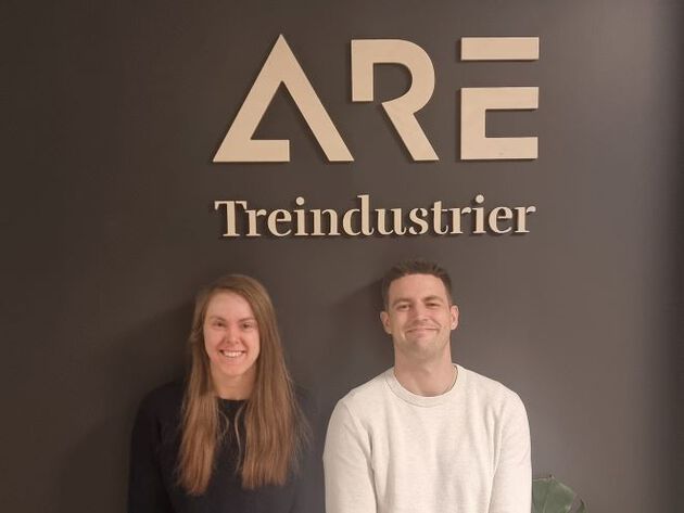 De to studentene står under logoen til "Are Treindustrier".
