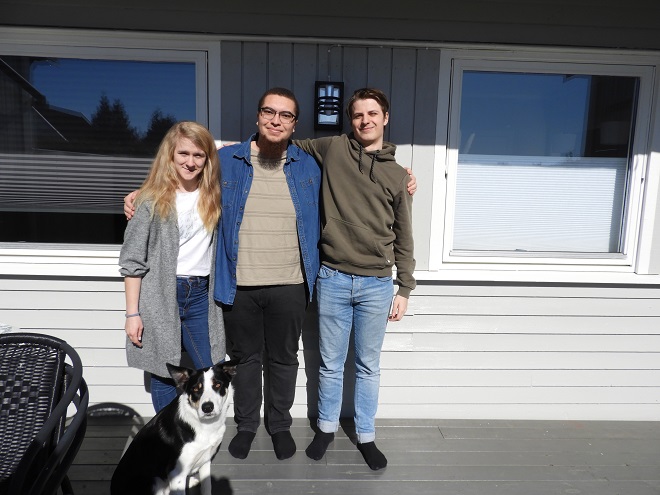 De tre prosjektdeltakerne Viktoria Jacobsen, Håkon Skogen og Eirik Skoglund står på rekke med hunden Theis i front.