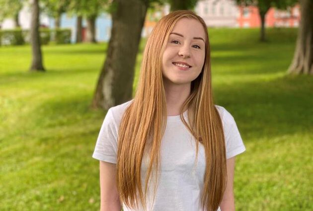 Profilbilde av Lotte Helland som står foran trær i en park.