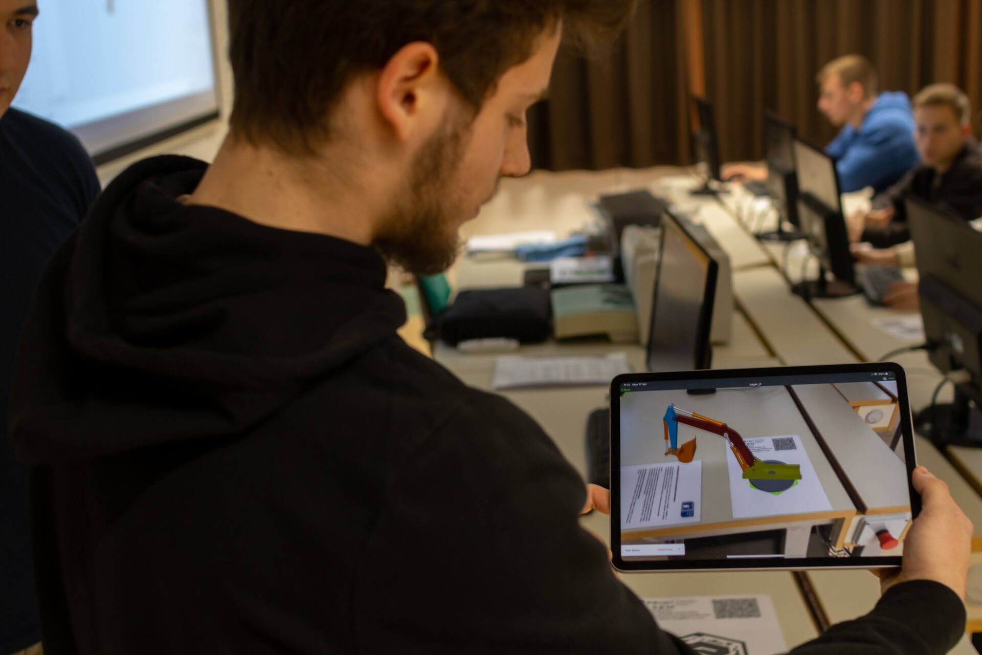 Student holding an Ipad displaying a 3D model