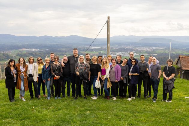 A group photo of all of the members of the study visit taken at the top of a mountain.