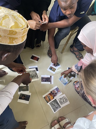 Several students are studying different cards lying at the floor between them