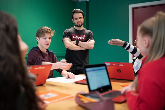 Bildet viser en lærer i undervisningssituasjon med elever. 