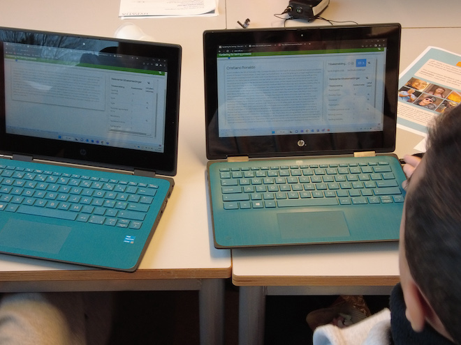 Bilde av elev foran to pc-skjermer med tekstprogram på
