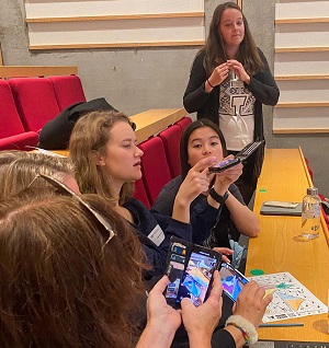 Bildet viser 5 kvinnelige studenter, som utforsker bruk av apper på telefon, til bruk i et undervisningsopplegg. 