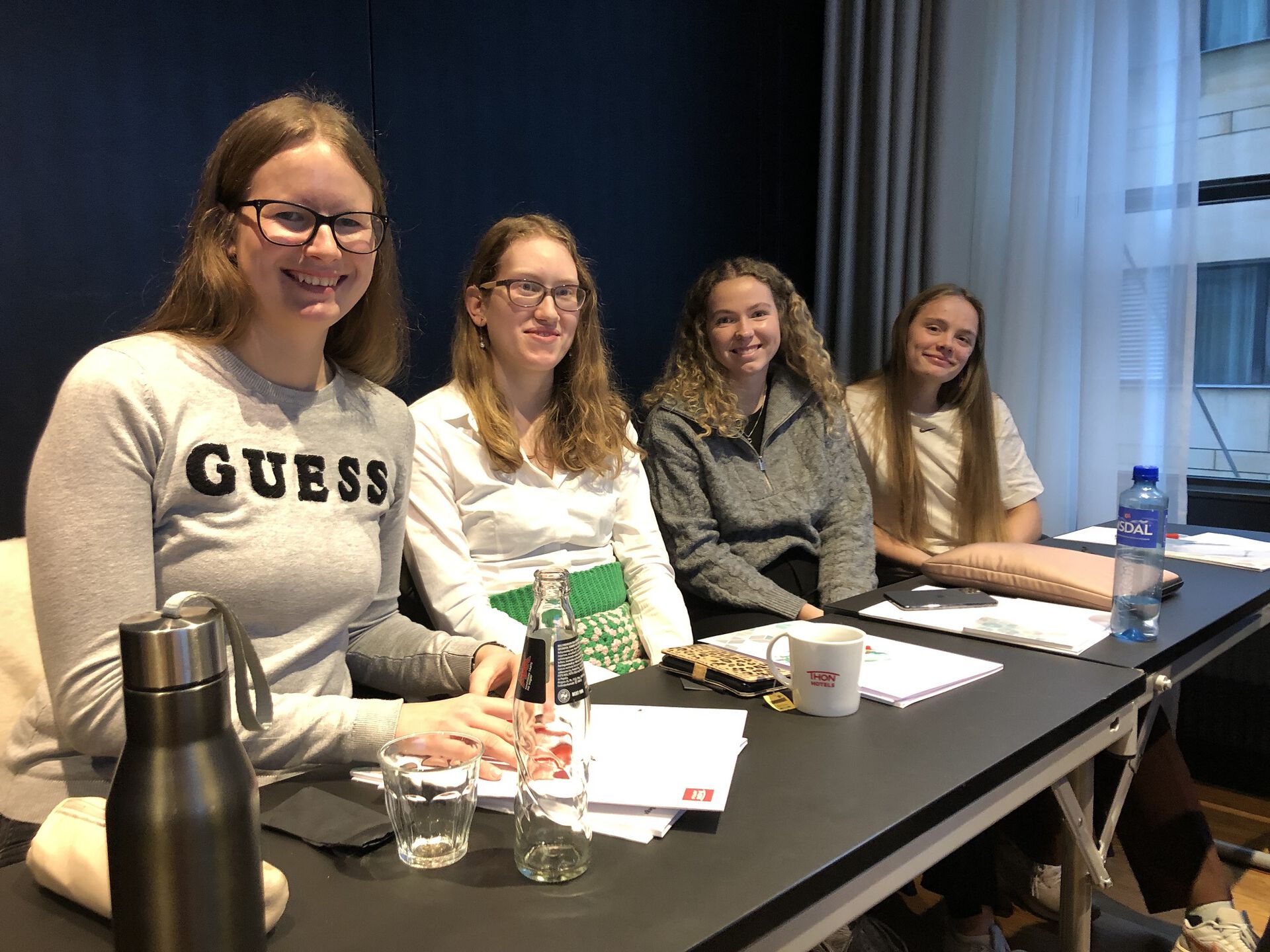 Fire studenter sitter ved et bord.