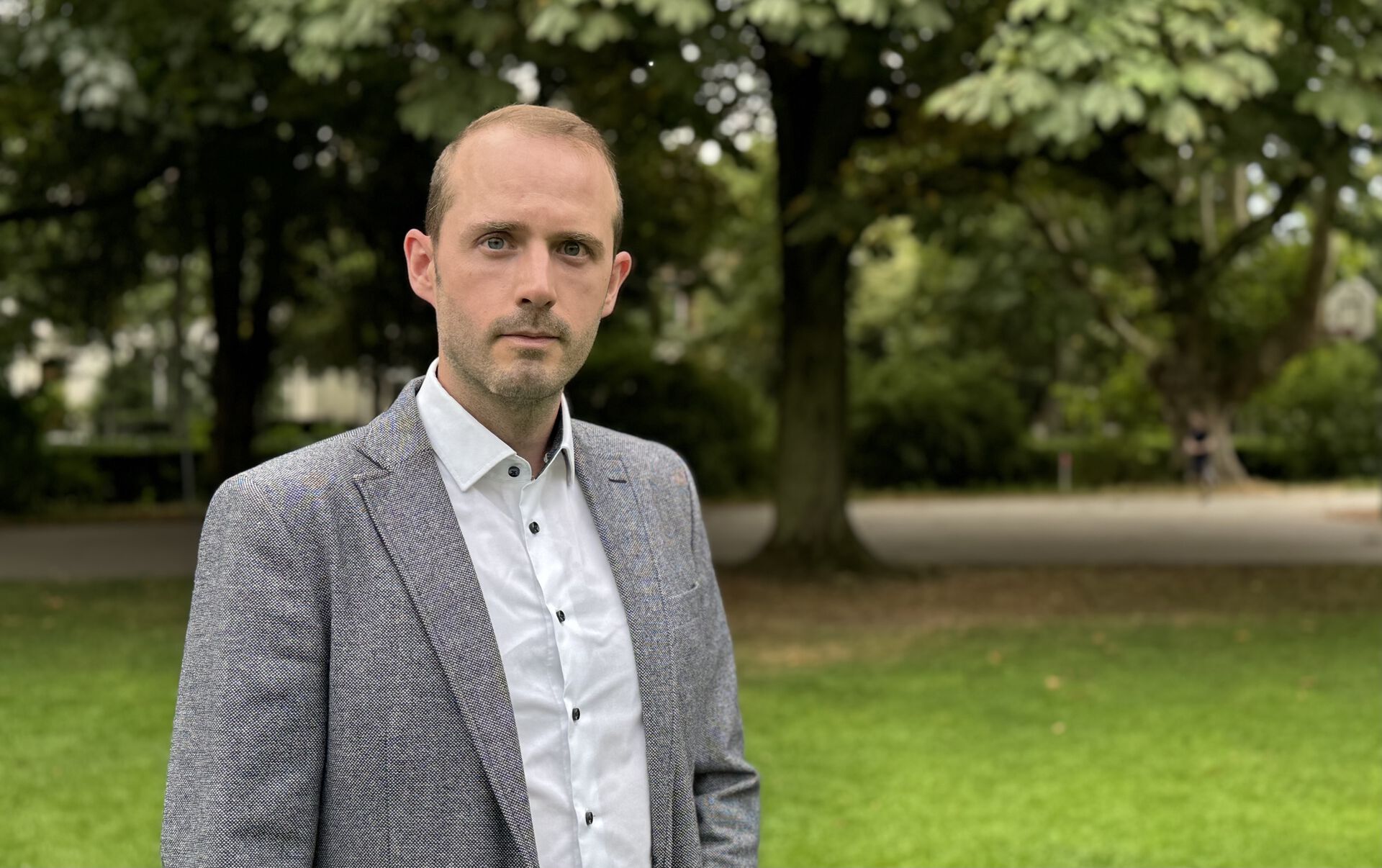 Bildet viser dekan Martin Hollmann avbildet utendørs i grønne omgivelser.