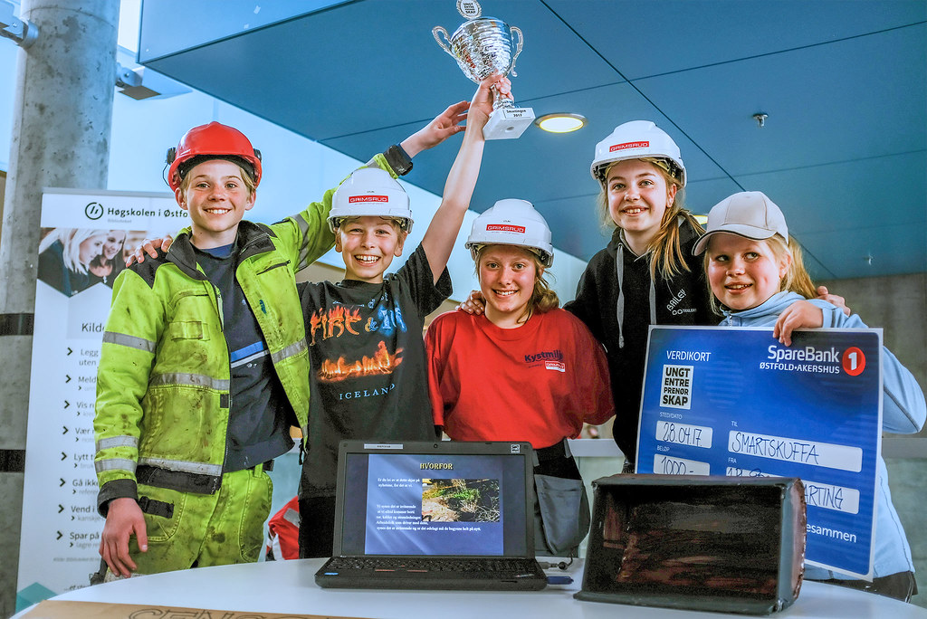 Bildet viser 5 elver, som holder opp en pokal og en sjekk for sin 1. plass i SMARTingen.