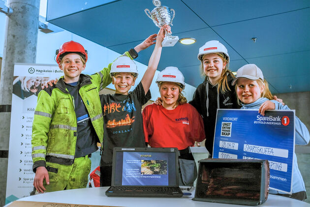 Bildet viser 5 elver, som holder opp en pokal og en sjekk for sin 1. plass i SMARTingen.