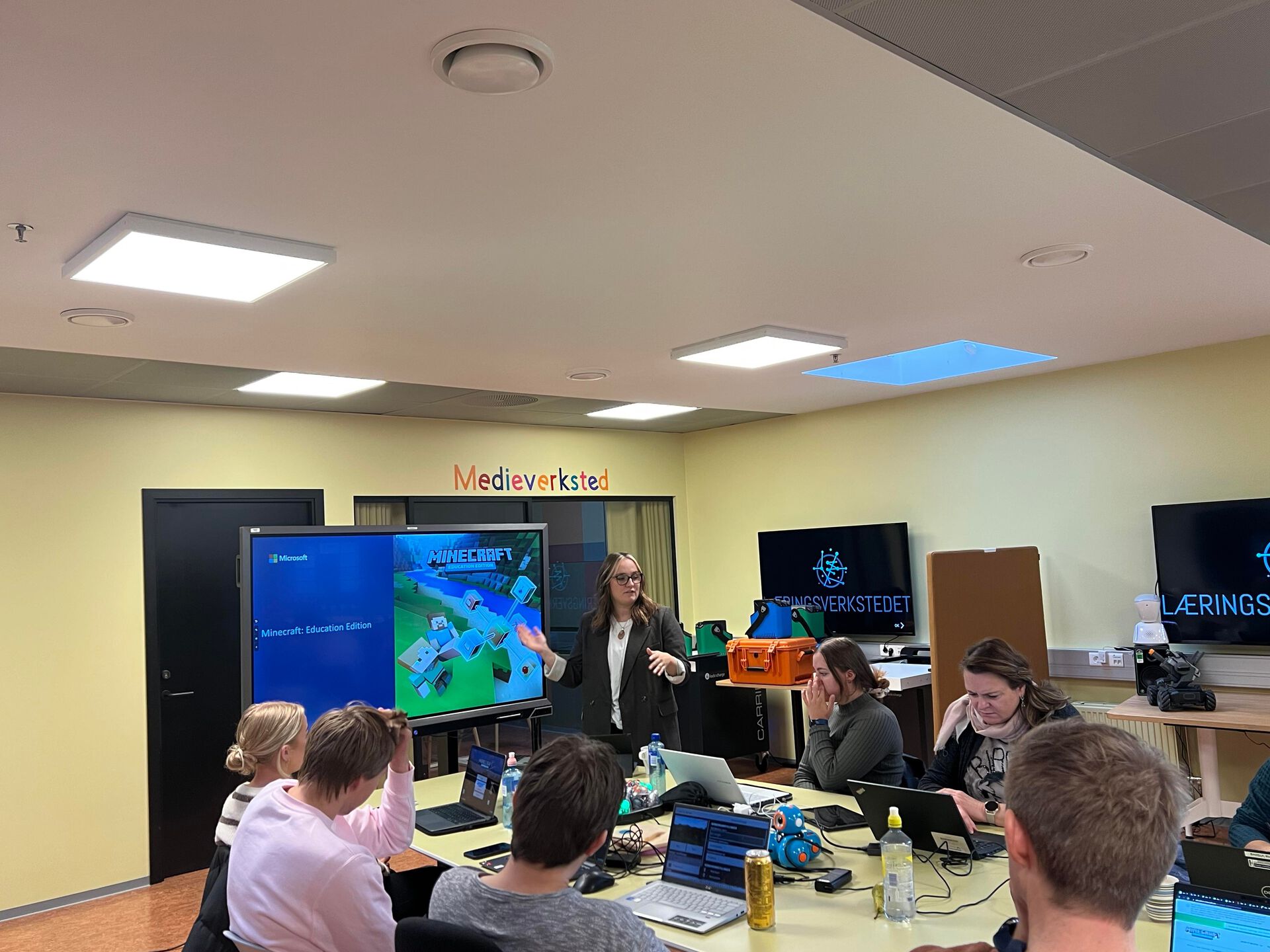 Maren Aasrud står ved digital tavle og viser minecraft