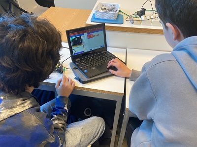 På bilete ser vi to elevar bakifrå, som ser på ein bærbar PC. 