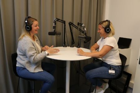 Cecilie og Stine som sitter rundt podkast-bord