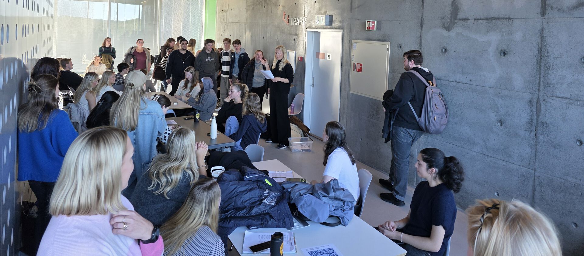 Bildet viser en gruppe studenter som får informasjon.