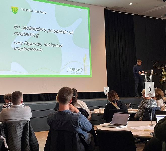 Bildet viser et oversiktsbilde over konferansen: tilhørere vises nederst i bildet, Lars Fagerhøi lenger oppe til høyre, og presentasjonen i et stort felt til venstre i bildet.