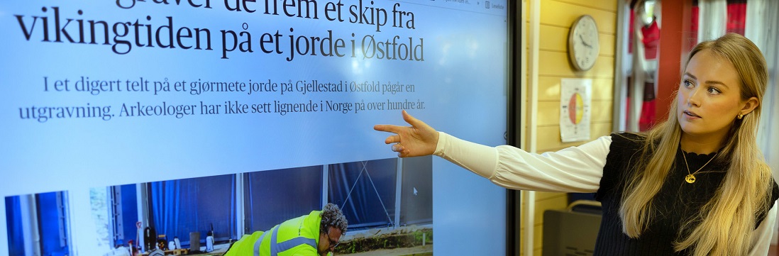 En kvinnelig studenter underviser ved hjelp av en digital skjerm