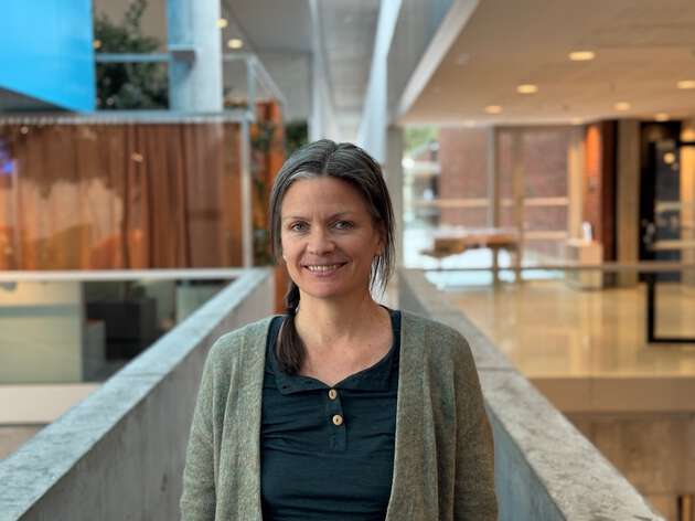 Bildet viser forsker Kristin Hagemann avbildet stående innendørs i høgskolens fellesarealer i Halden. 