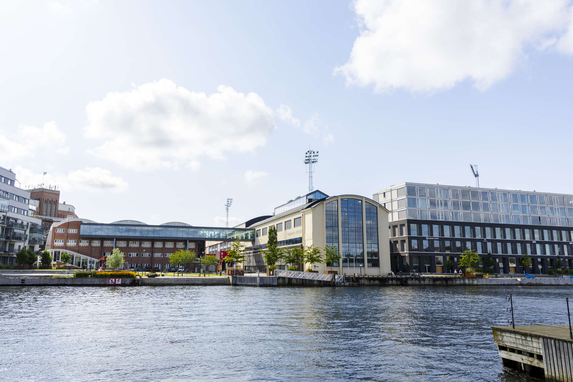 Bilde av campusbygningene på Kråkerøy, sett fra elvebredden.