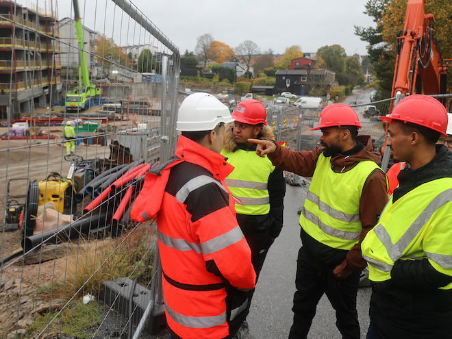  Ingeniør Hiwa Ahmad Mamand prater med tre av studentene som er på besøk ute på anleggplassen. Foto.