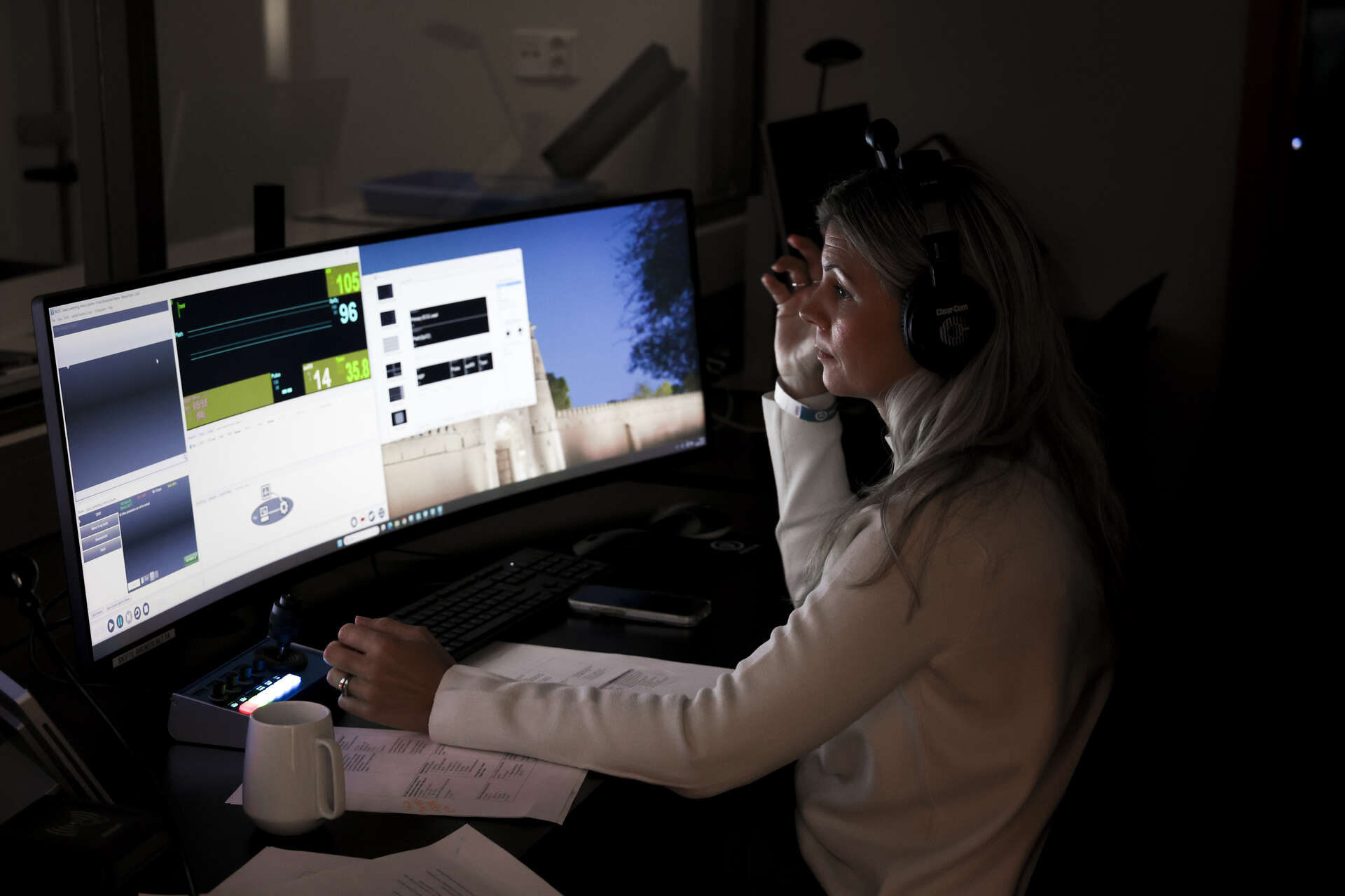 En med øreklokker følger nøye med på to skjermer med vitalia fra simuleringen. Foto.
