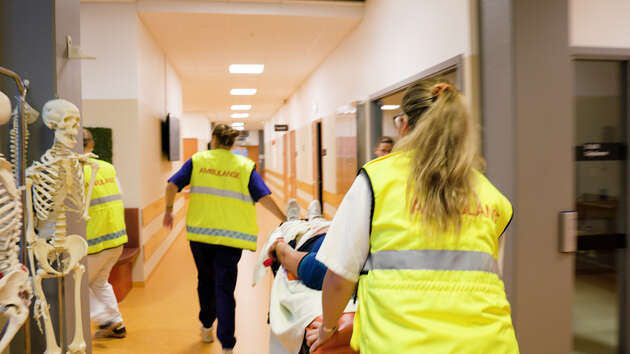 En pasient på båre trilles raskt gjennom gangen på simuleringssenteret.