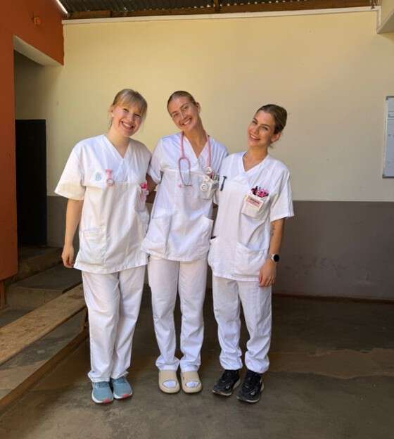 tre studenter i scrubs murgulv murvegg