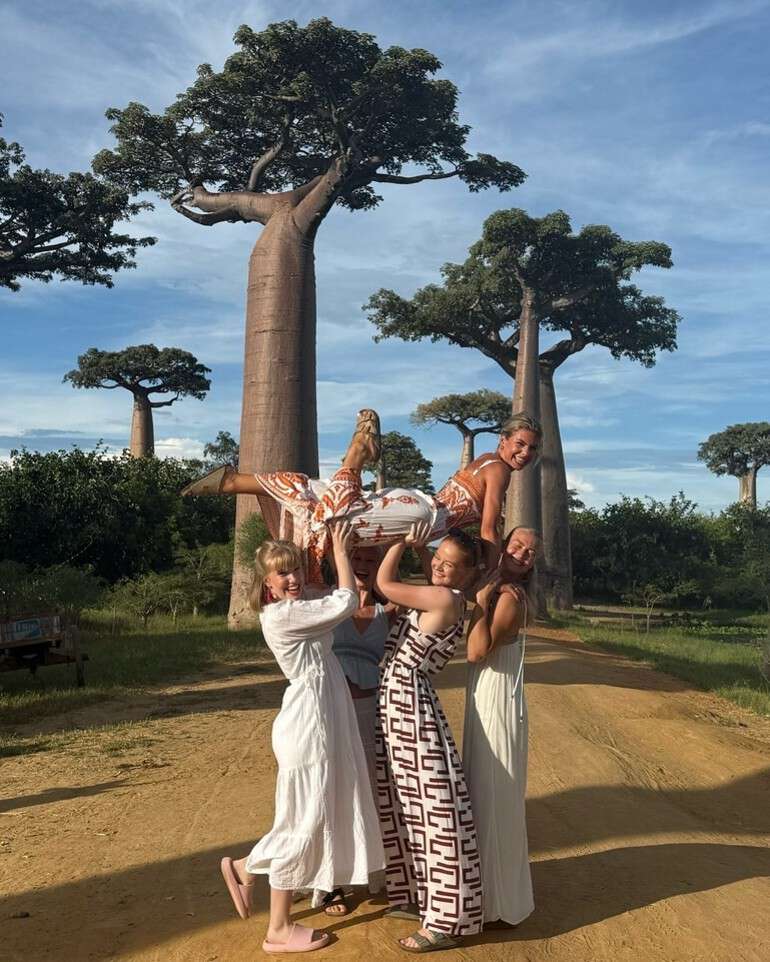 tre studenter løfter den fjerde himmel baobabtrær grusvei