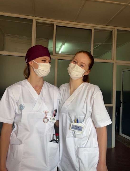 Studenter scrubs ansiktmasker glassvegg