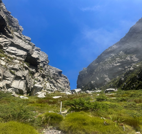 gråstein ravine grønt gress blå himmel