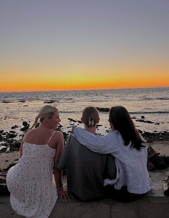hav strand solnedgang tre studenter med ryggen til