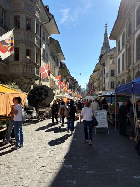 Gågate i Bern folk bygninger himmel flagg